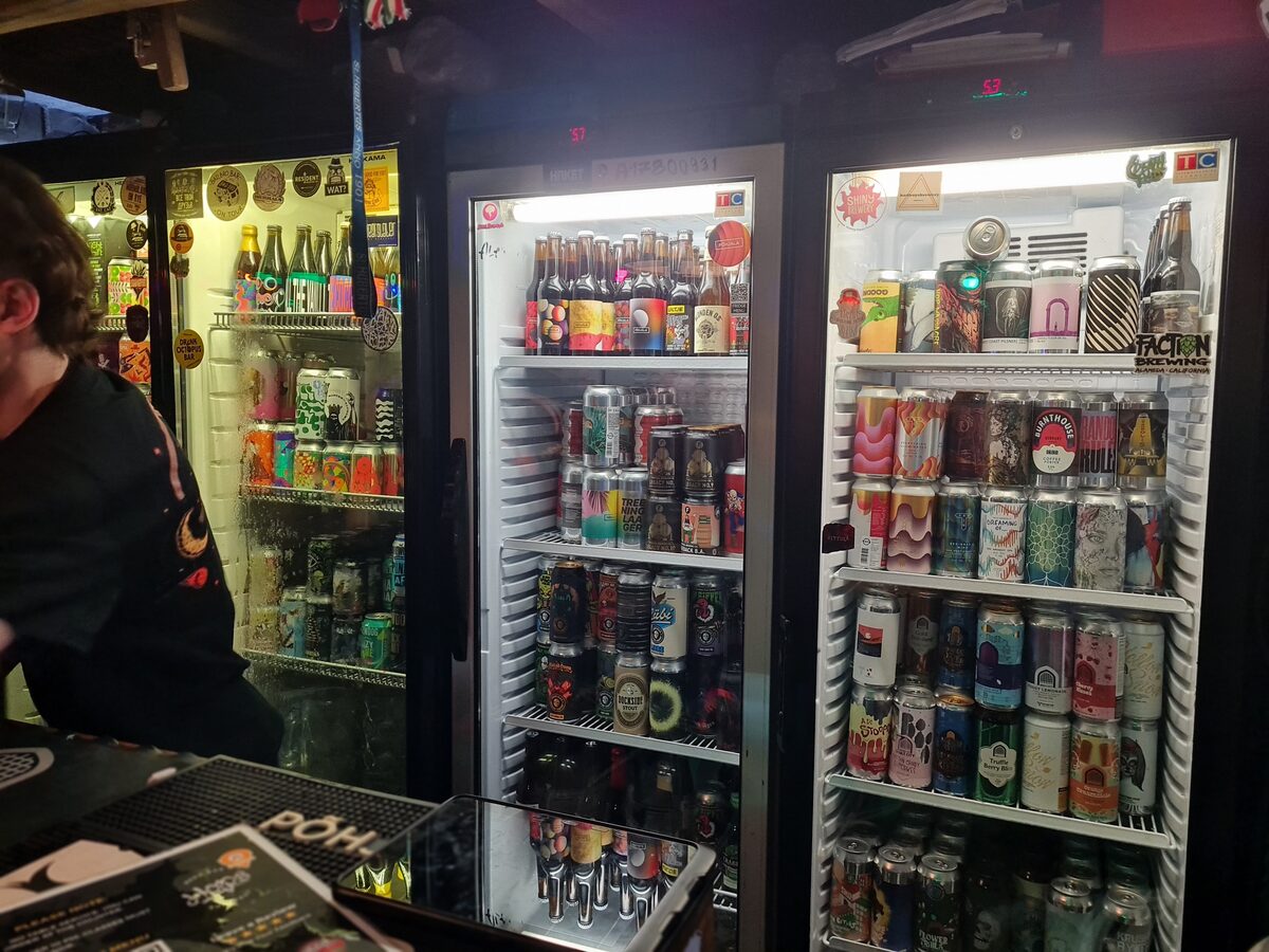 Fridge stocked with craft beer cans at HOPS Beer Bar Budapest