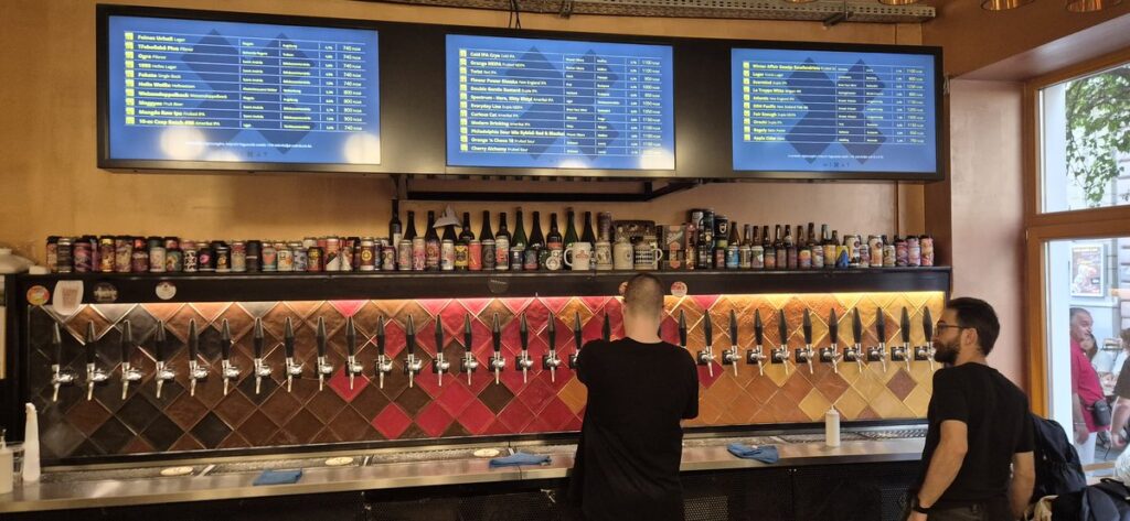 Mixát Udvar Budapest craft beer tap wall with digital menu screens and large selection