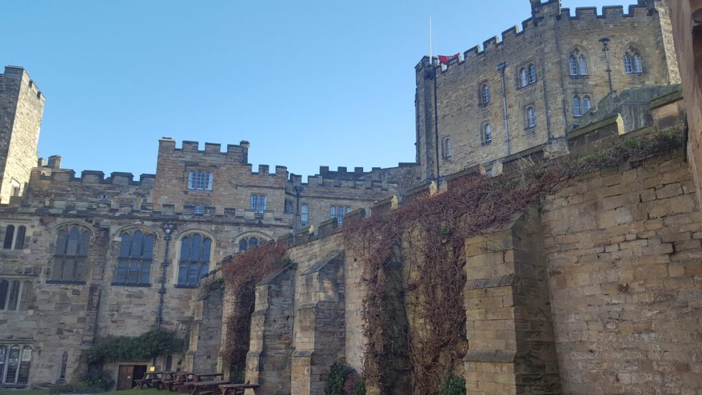 The curtain wall and ranges of Durham Castle seen from the street below
