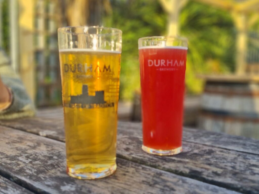 A pale Magus and a red Currant Chaos in Durham Brewery glasses on an outdoor table