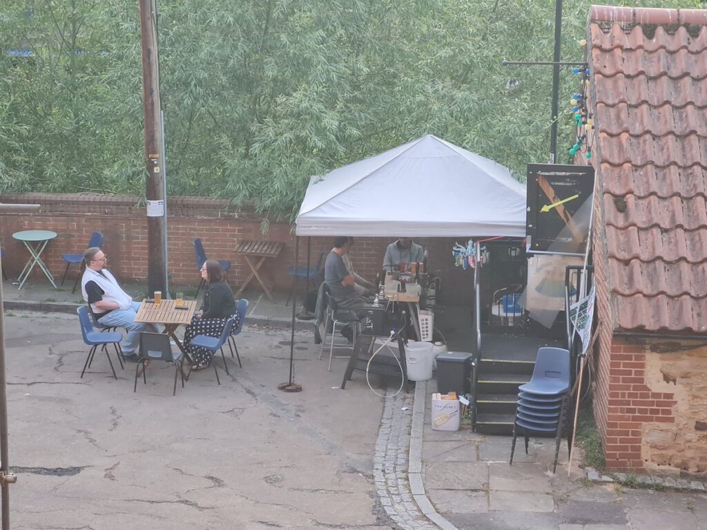 Tables and drinkers in Fowler’s Yard, Durham, with the Hill Island Brewery gazebo behind