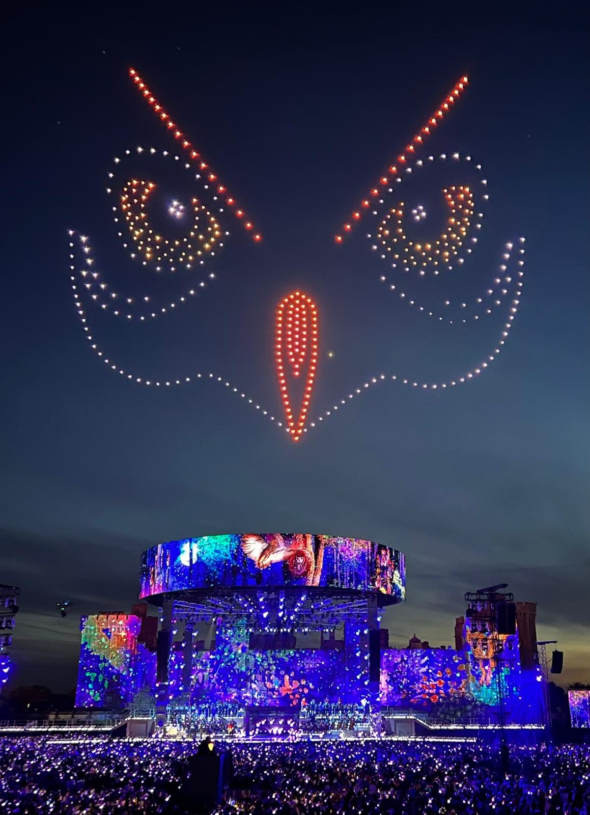 Drones forming a glowing owl face in the night sky above the illuminated Coronation Concert stage at Windsor Castle