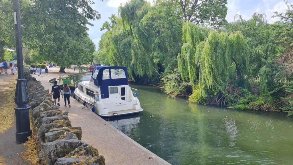 Riverside path beside the Thames at Windsor with willows and a moored boat