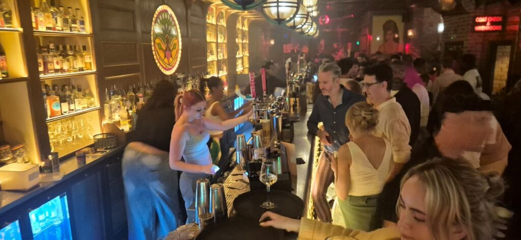 A busy bar at the Blues Kitchen in Camden late at night, with staff pouring and a crowded room behind