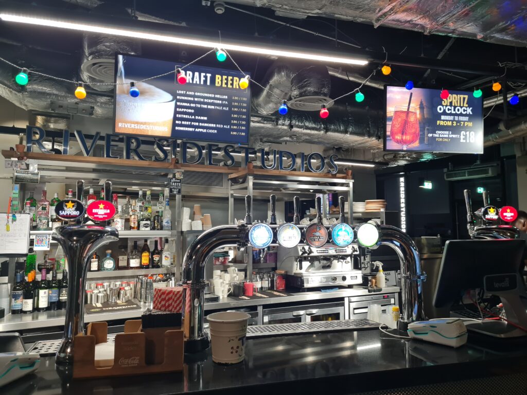 The bar at Riverside Studios, Hammersmith, with the draft beer board above it