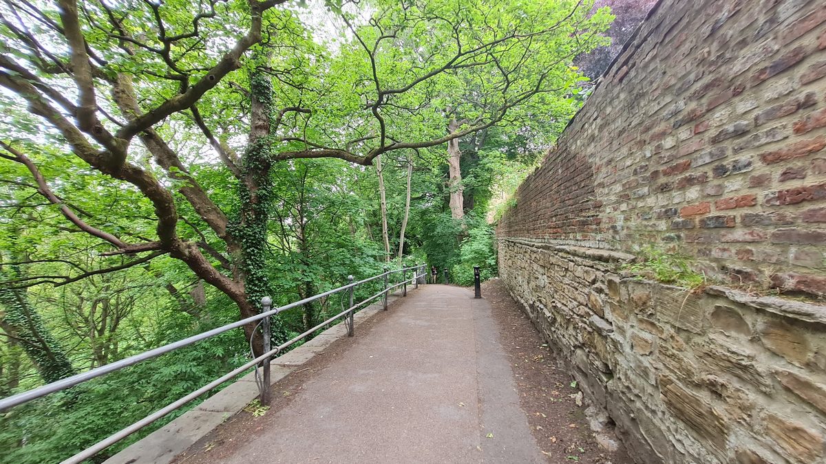 Riverside path running beneath the old retaining walls of the Bailey, Durham