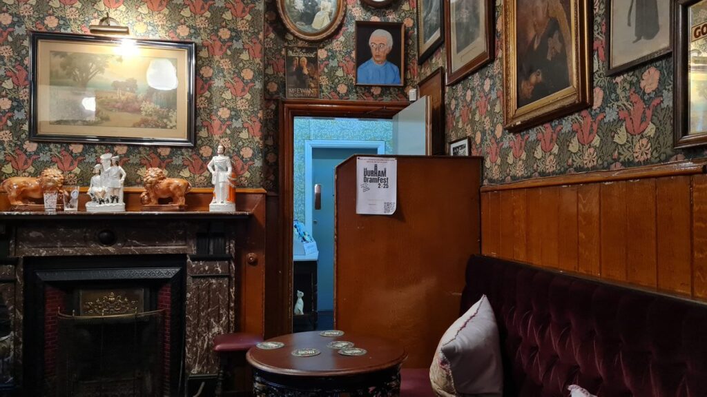 The back sitting room with fireplace and original wallpaper at The Victoria Inn, Durham