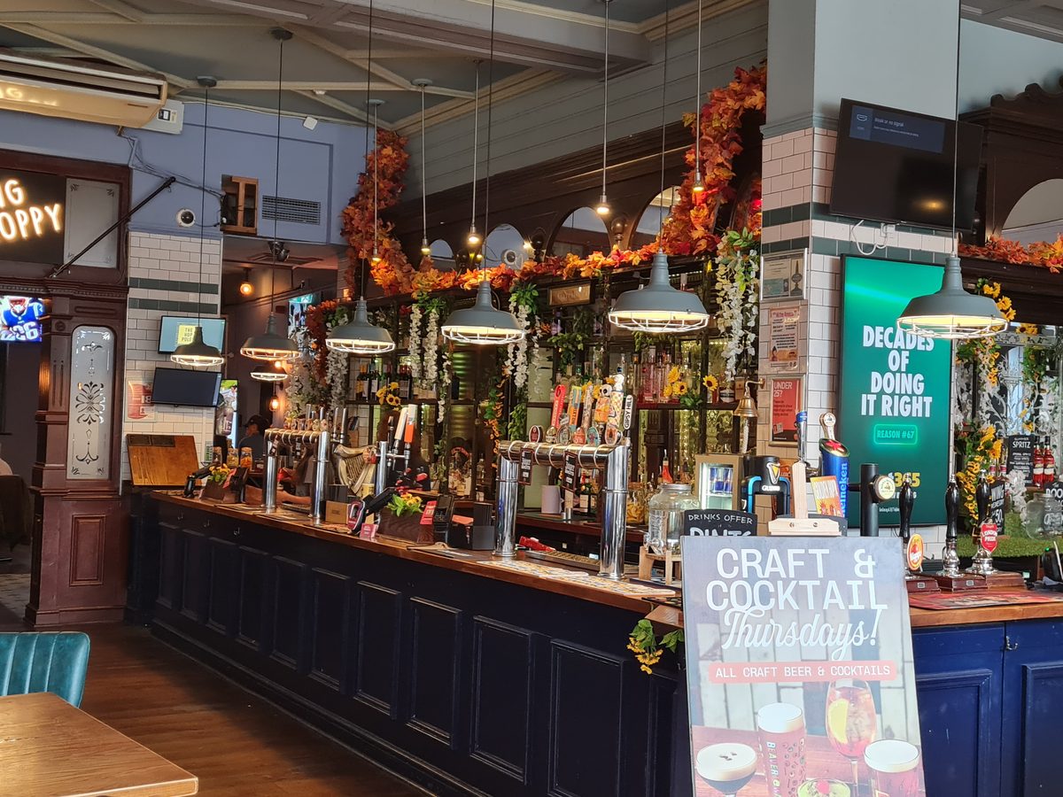 The long bar and cast-iron columns inside the Hop Poles, Hammersmith, London