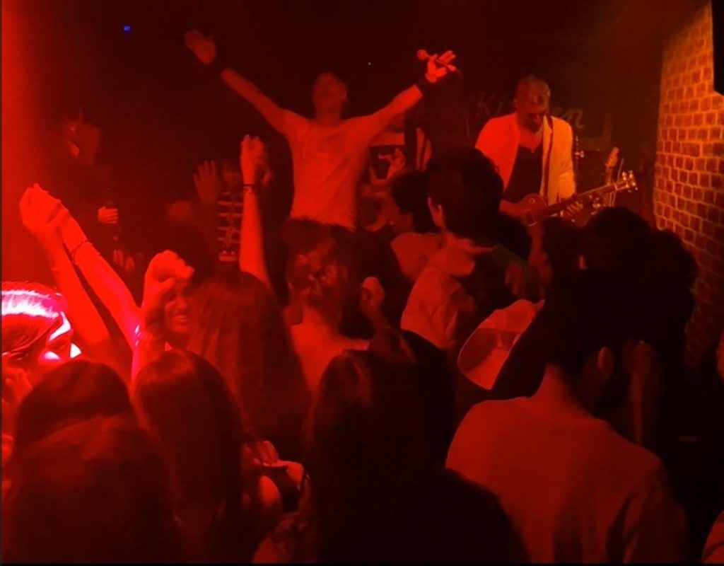 A crowd under red stage lights at a live music night in the Blues Kitchen, Camden, London