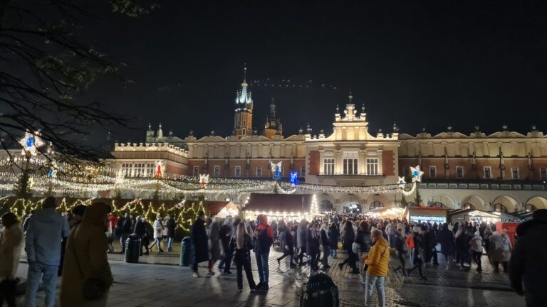 Kraków Christmas market at night with the Cloth Hall lit up on the Main Square