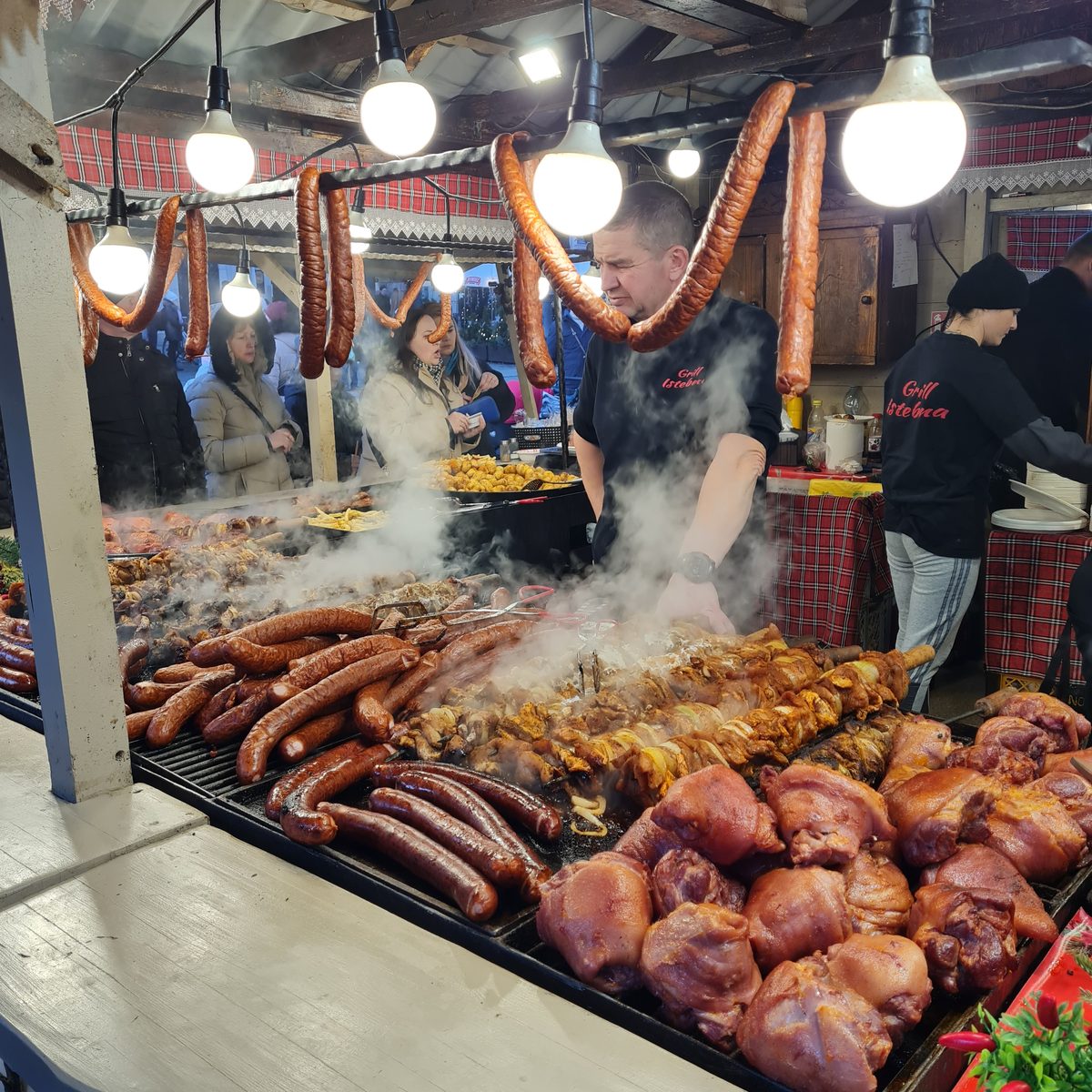 Sausages and pork knuckles on the grill at the Kraków Christmas market