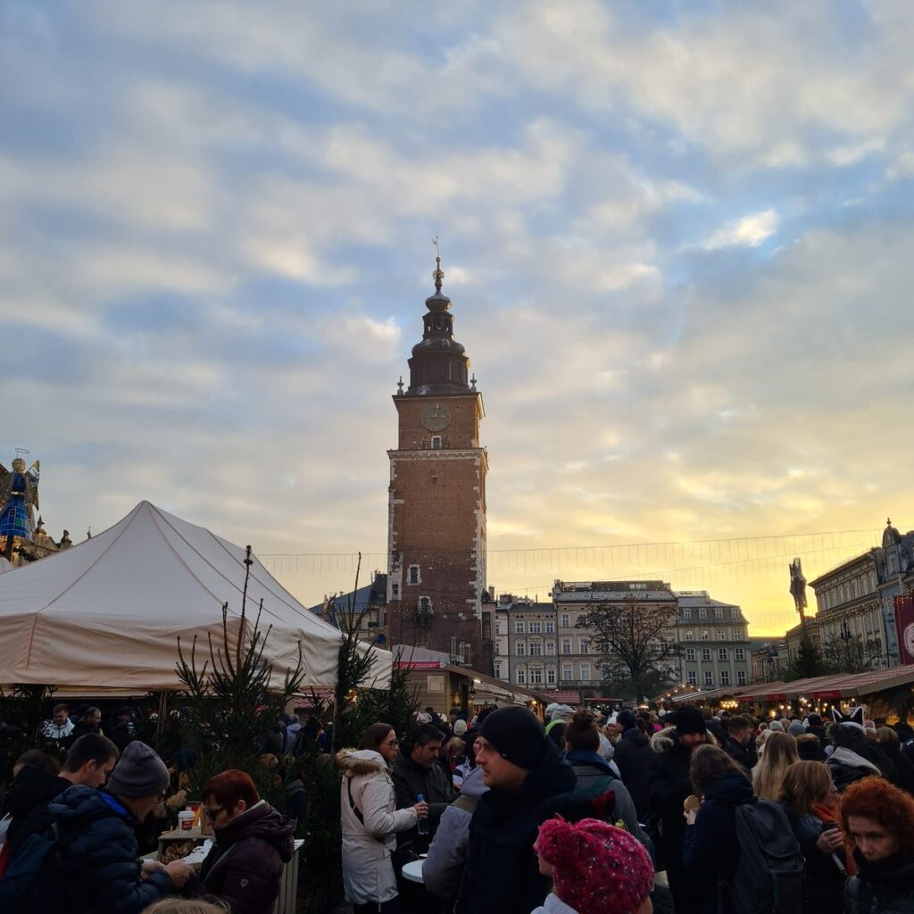 The Town Hall Tower above the Christmas market crowds at sunset, Kraków