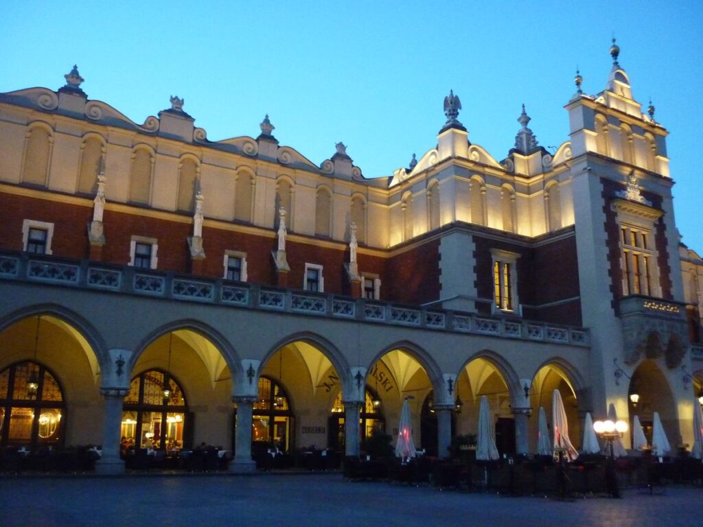 The Cloth Hall arcades lit up at dusk on Kraków's Main Market Square