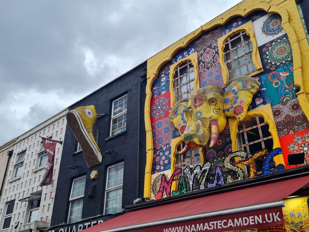 A giant boot and a painted elephant mounted above a shopfront on Camden High Street, London