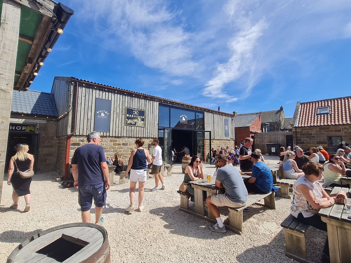 Picnic benches on the gravel outside Whitby Brewery