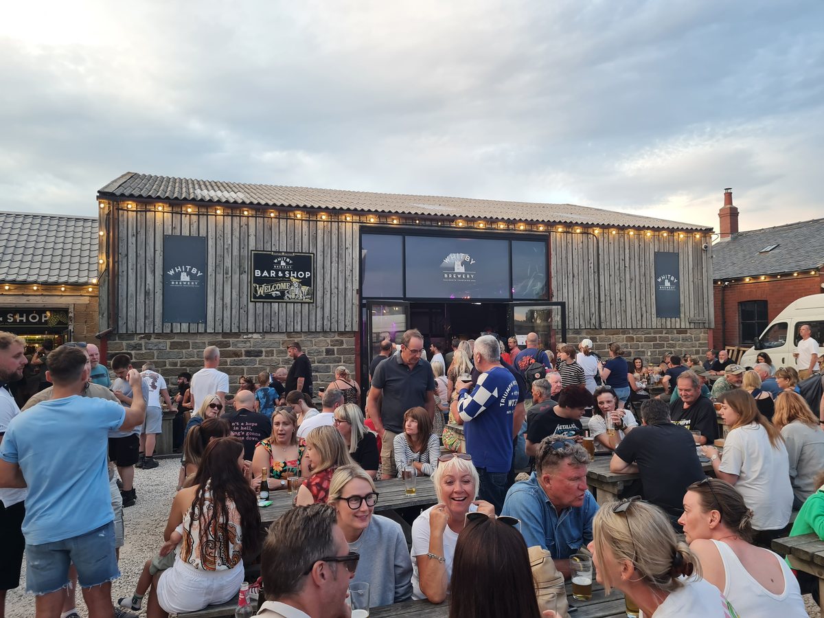Outdoor tables busy outside Whitby Brewery in the evening