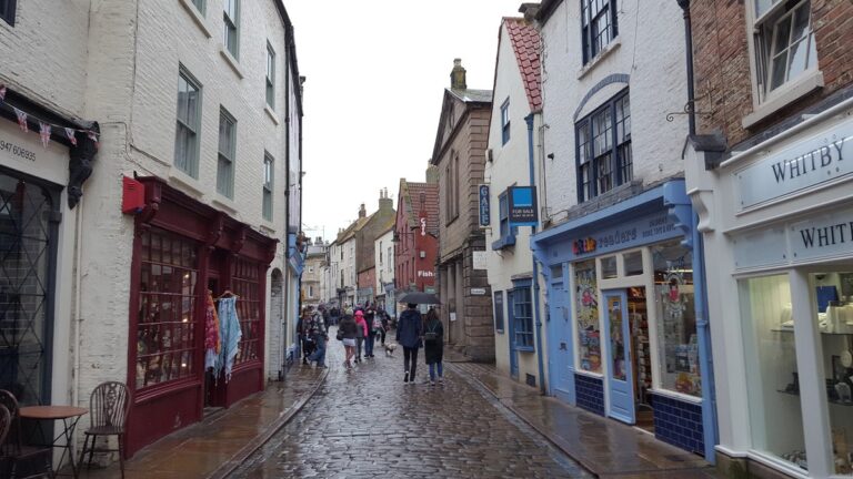 Wet cobbles and shopfronts on Church Street, Whitby, on a rainy day