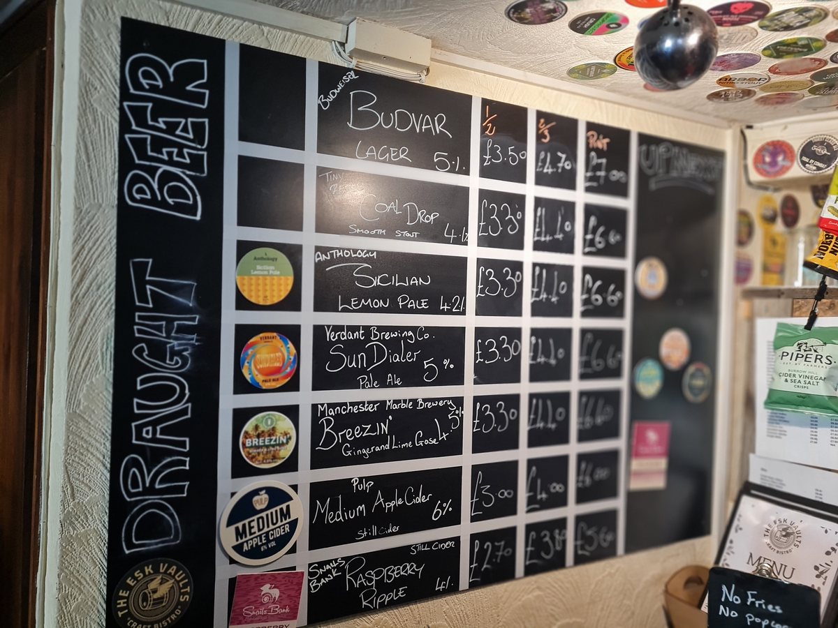 Chalk draught beer board listing five beers and two ciders at The Esk Vaults, Whitby