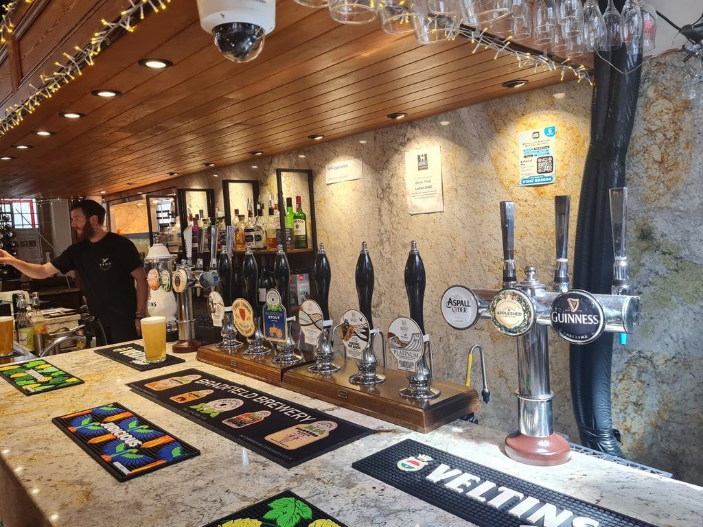 The bar at the Helmsley Brewing Co Tap Room in Whitby, with hand pulls and keg taps under the vaulted roof of the old chapel